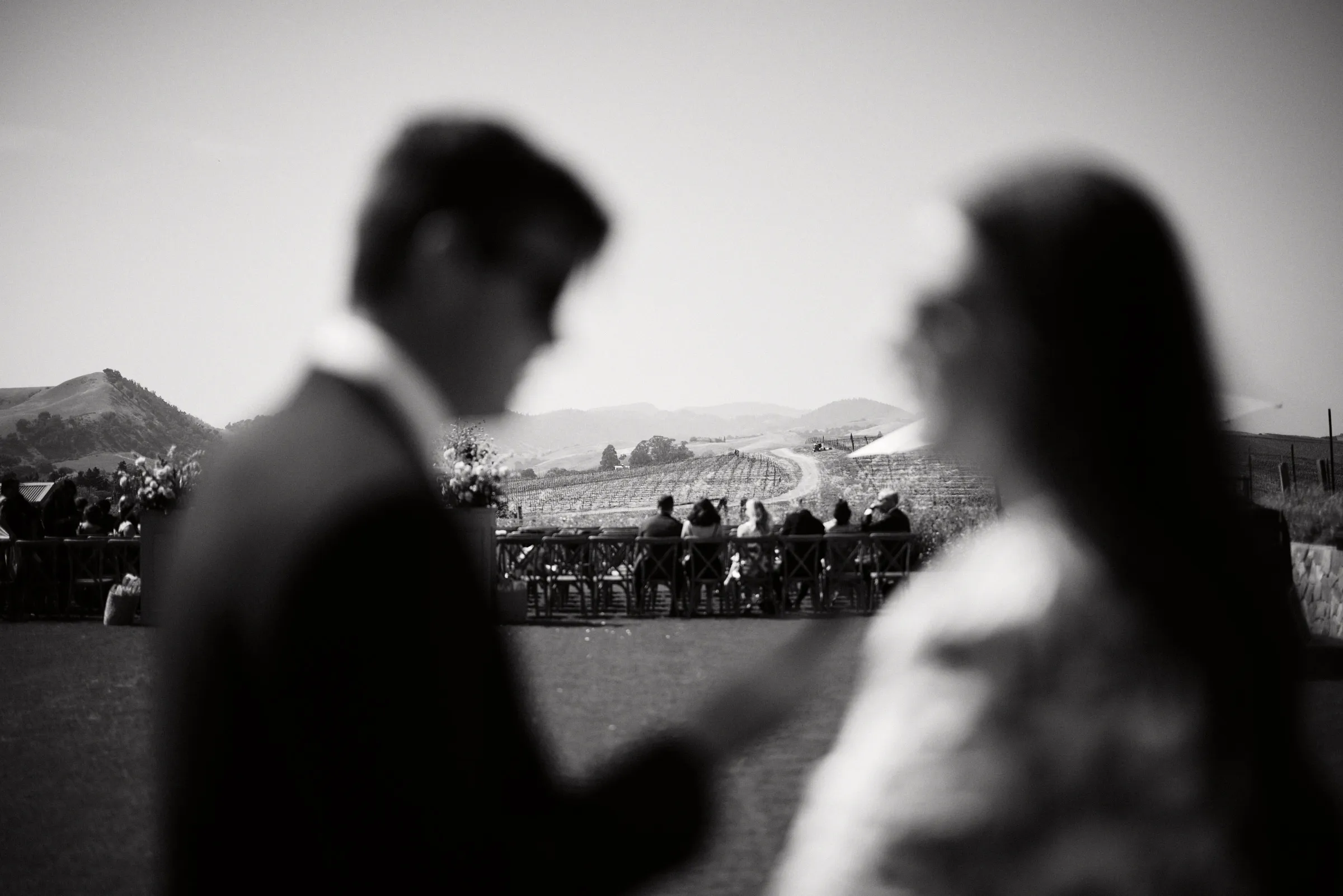Guests gathered beyond the couple, in black and white