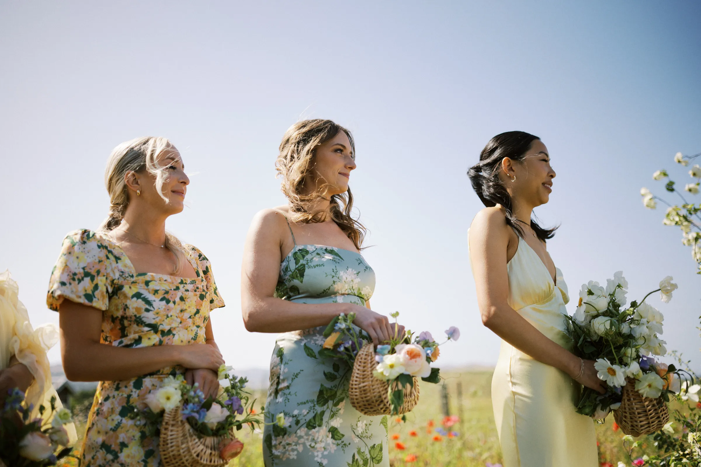 Bridesmaids with baskets of flowers in the field