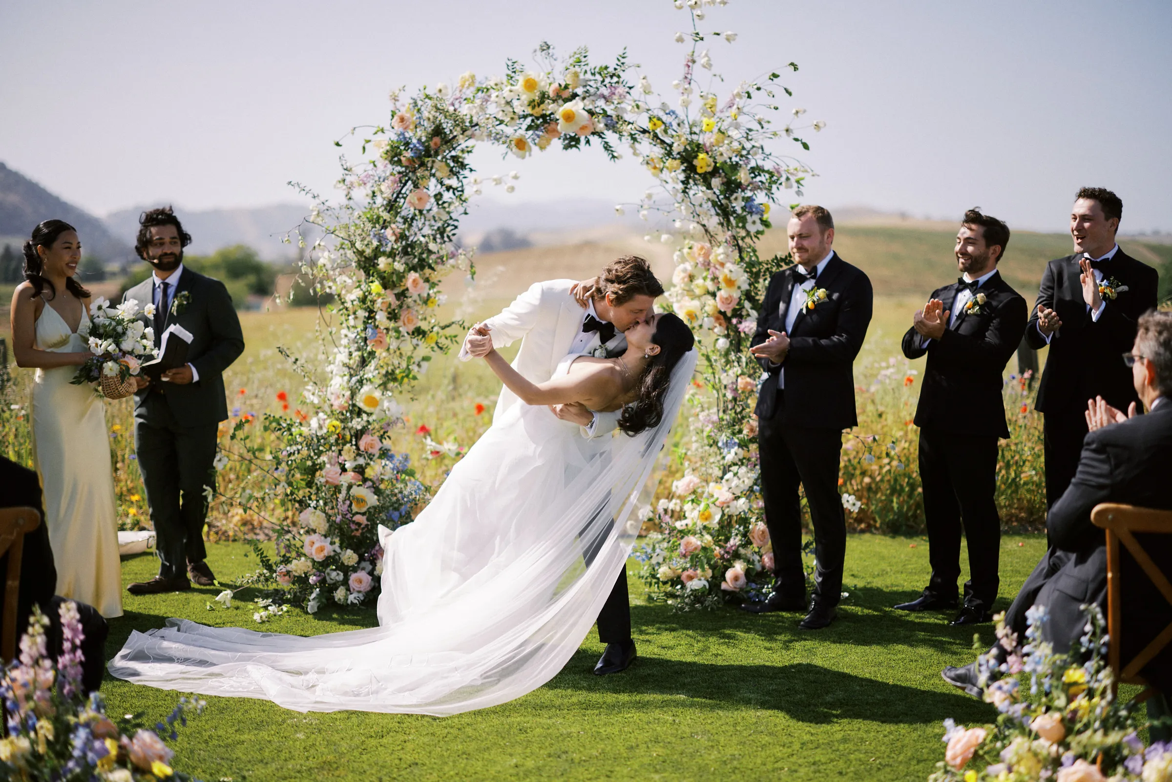 The kiss beneath the floral arch